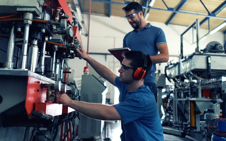 Deux techniciens assemblent une machine industrielle dans l’atelier